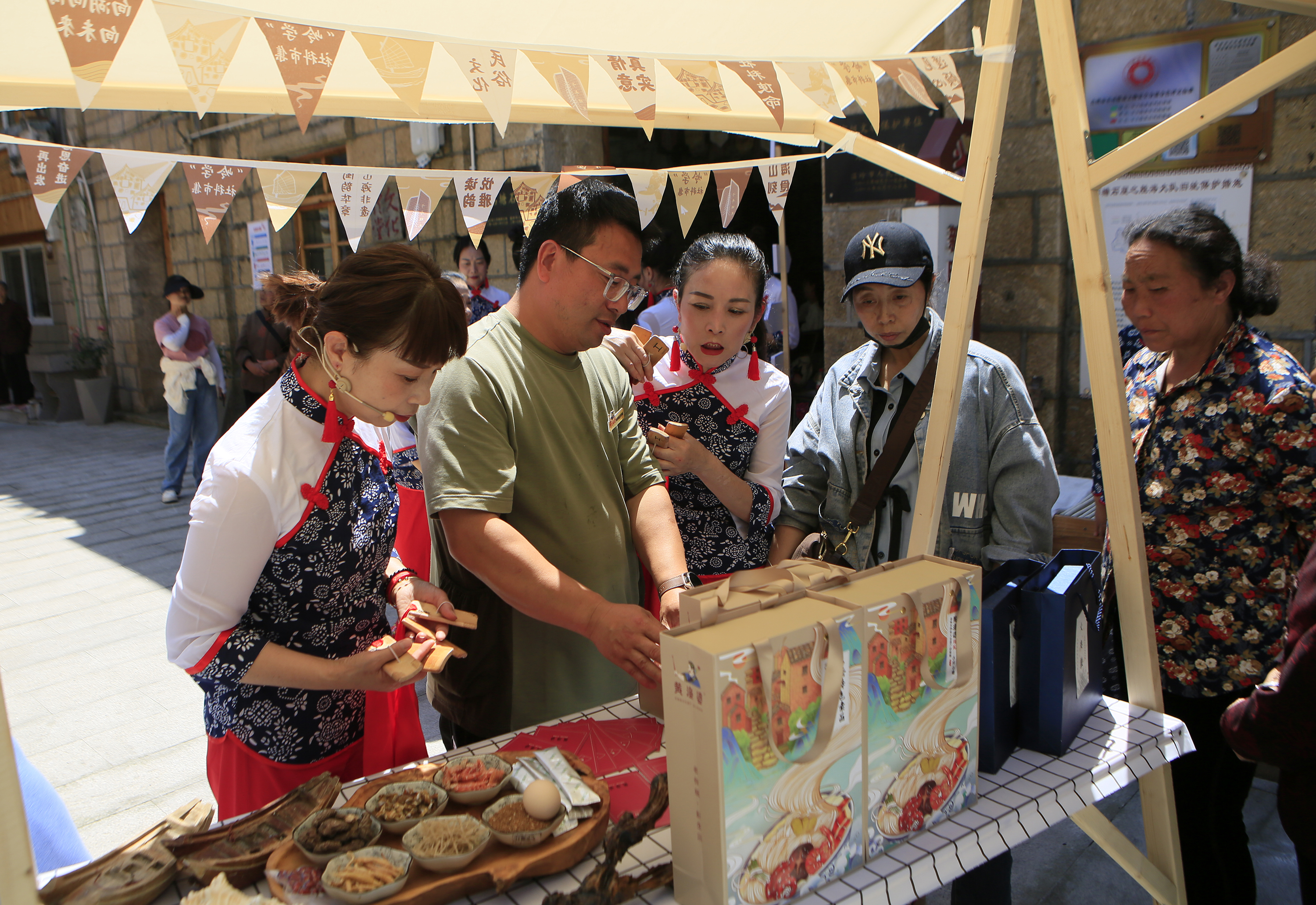 展位上,大奏鼓盲盒,鹅卵石画,蟹壳画,海洋剪纸,船模等石塘当地创意