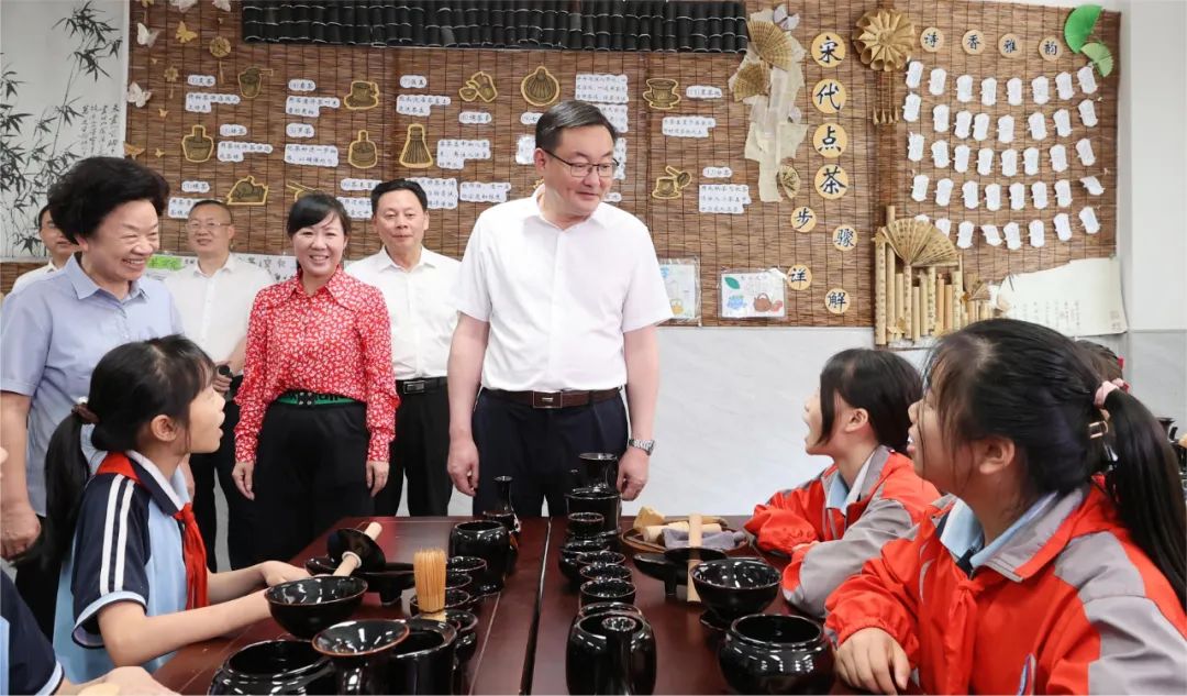 吉安市保育院的小朋友们向罗文江一行介绍自己搭建的"恐龙岛",邀请