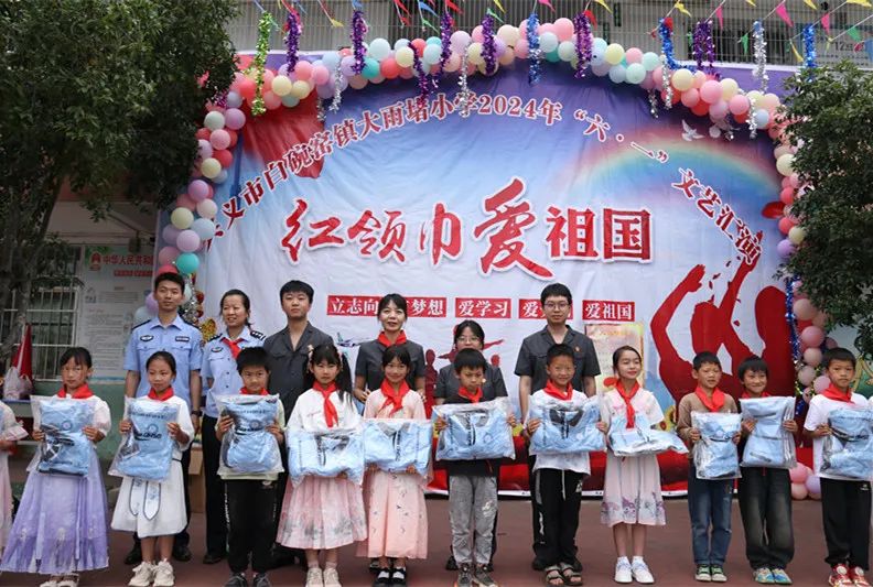 兴义市法院干警给全校学生送来了六一儿童节礼物——崭新的校服,为