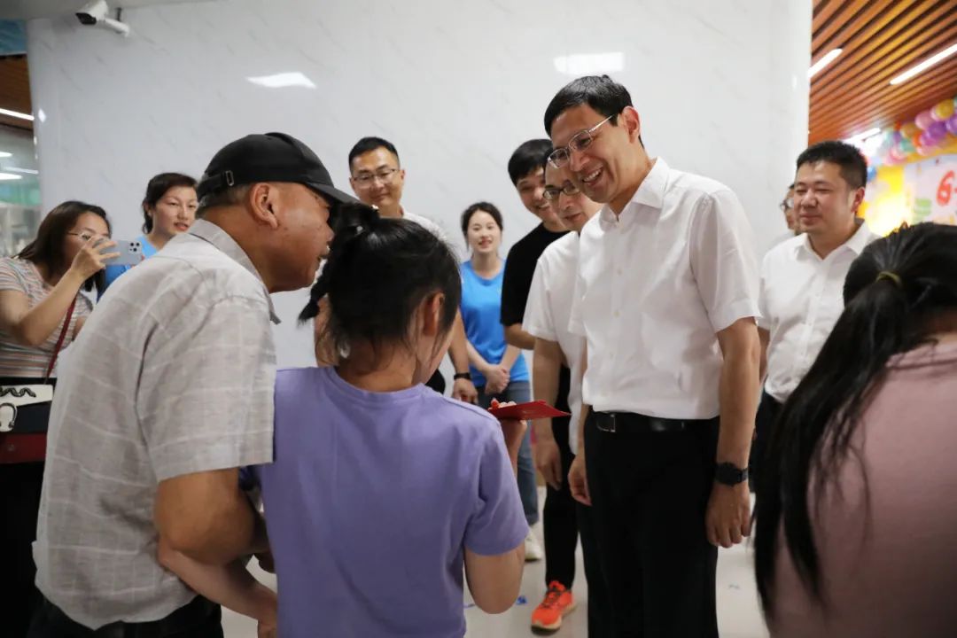 "在"六一"活动现场,许锋与正在参加趣味活动的孩子们互动交流,并送上