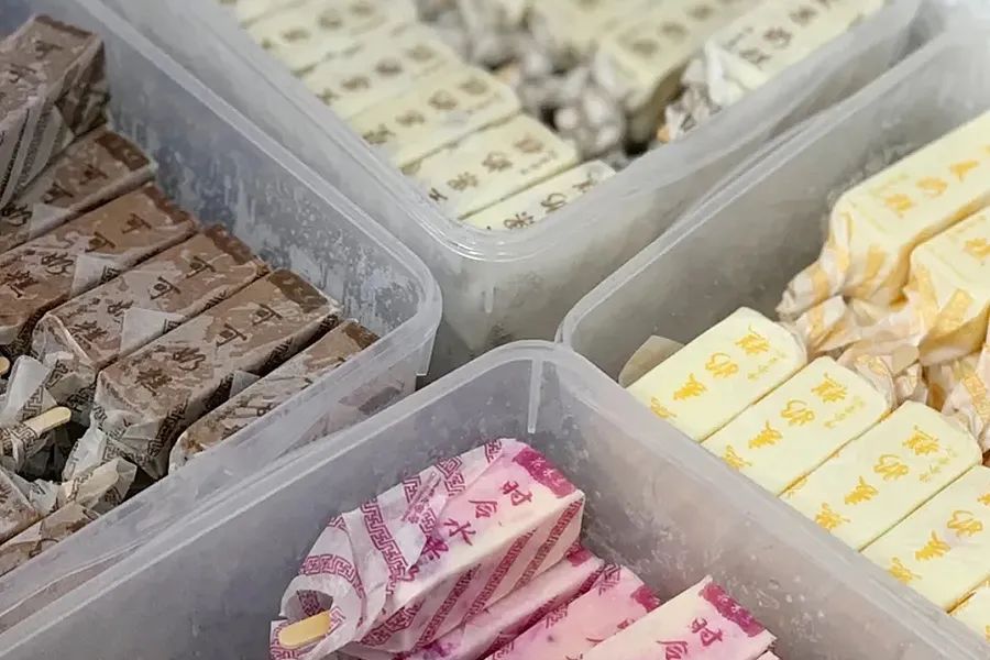 80,90年代,街头小卖部冰柜,路上孩子手里,都是白底橙字的纸包装.