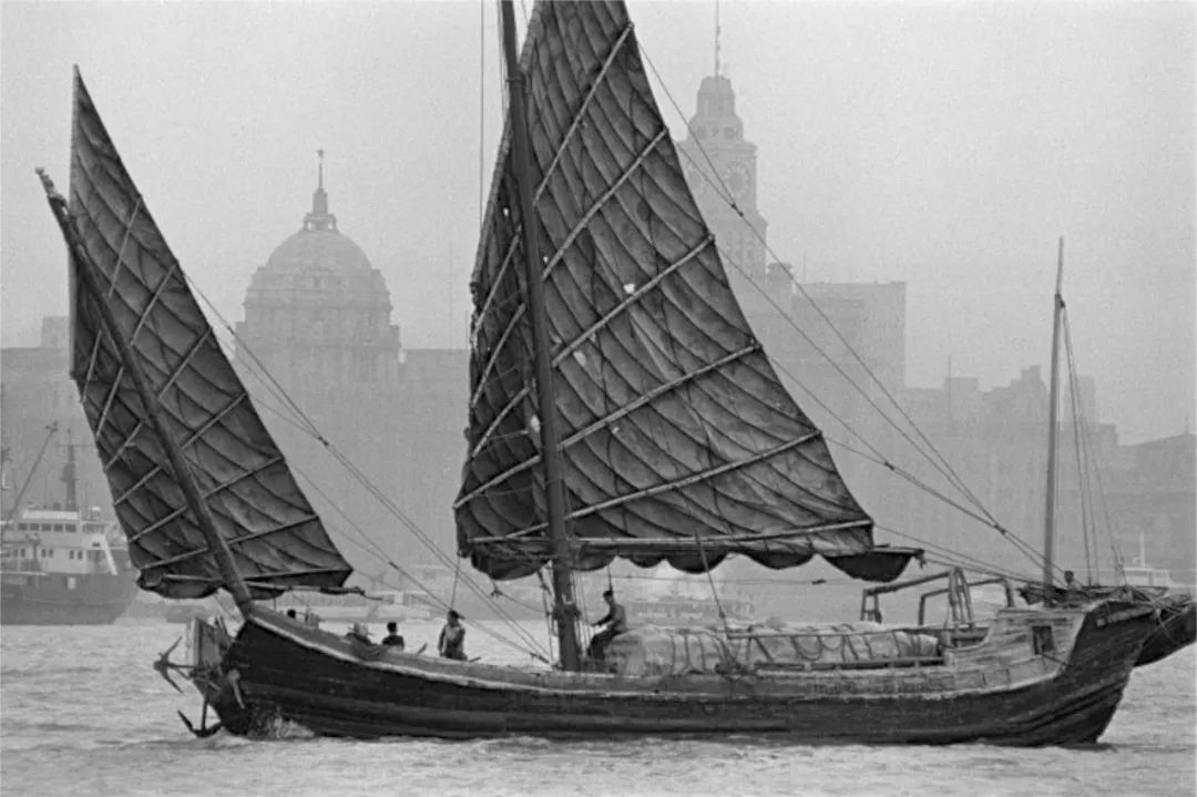 1979年,黄浦江上的沙船与背景中的外滩建筑群相得益彰图片摄影