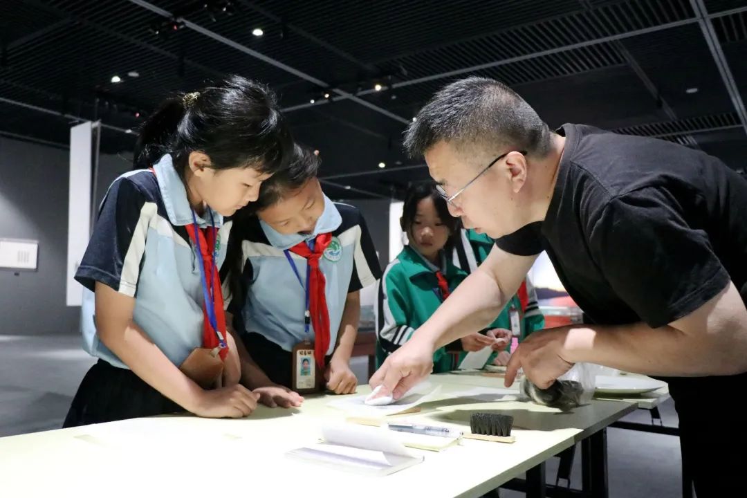观展期间,沧州市水月寺小学的学生在老师的指导下,轻轻按压刻板,沉浸