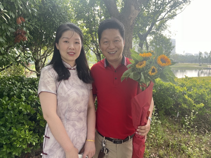 现场,记者看到一对夫妻手持向日葵为女儿送考,"我夫人穿的旗袍寓意着