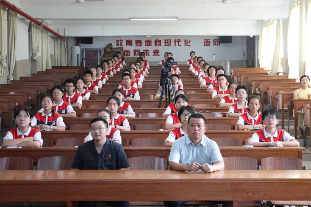 九年级27班同学现场旁听,全校3000余名学生则在教室通过直播同步听课.