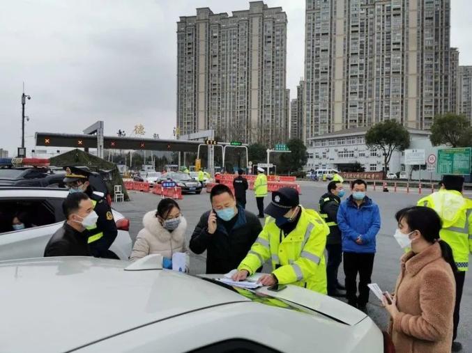 与综合执法人员在g50高速长兴西出口对入城人员进行登记,体温检测许要