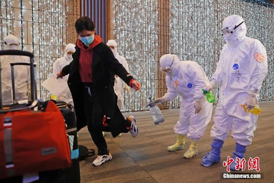 3月16日,上海的工作人员对旅客进行全身消毒.中新社记者 殷立勤 摄