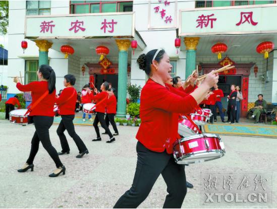附近广场舞爱好者在冯菊华家院子里跳军鼓舞。(记者 成青 摄)