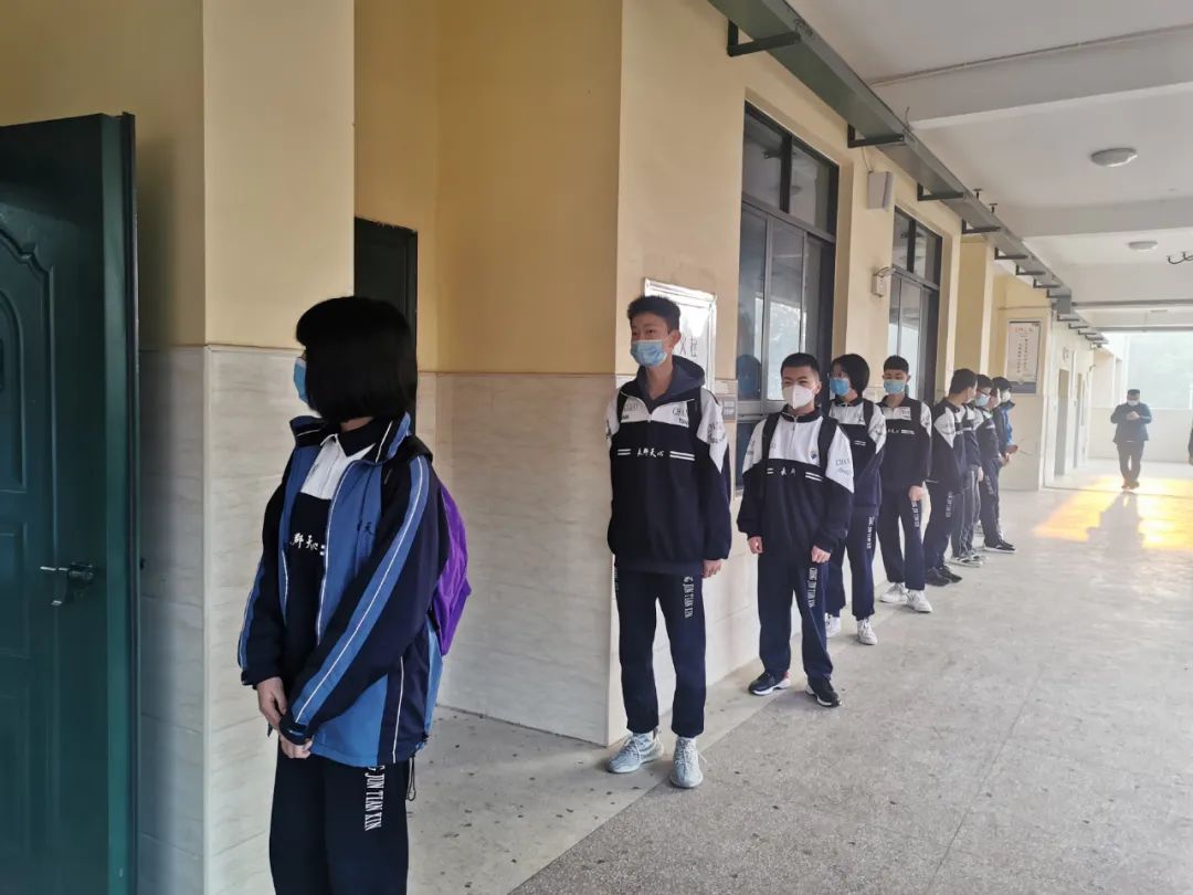披塘中学进入教室前再次排队测温.