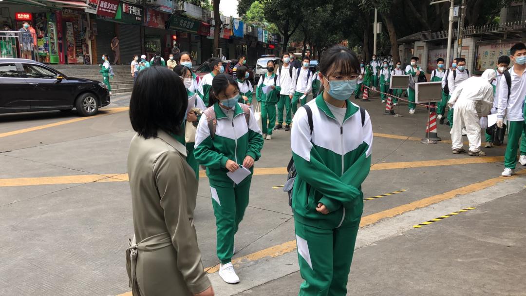 返校首日早晨6时50分许,执信中学(执信路校区)门前,同学,老师依次