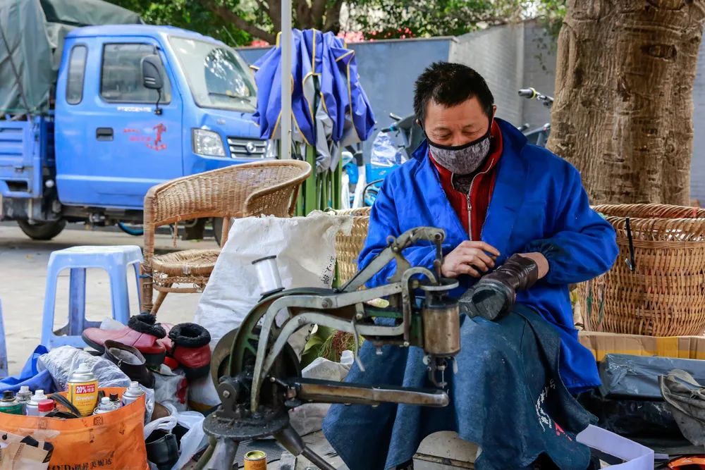 2020年3月3日,四川南充市延安路街边补鞋摊的师傅正为顾客补鞋.