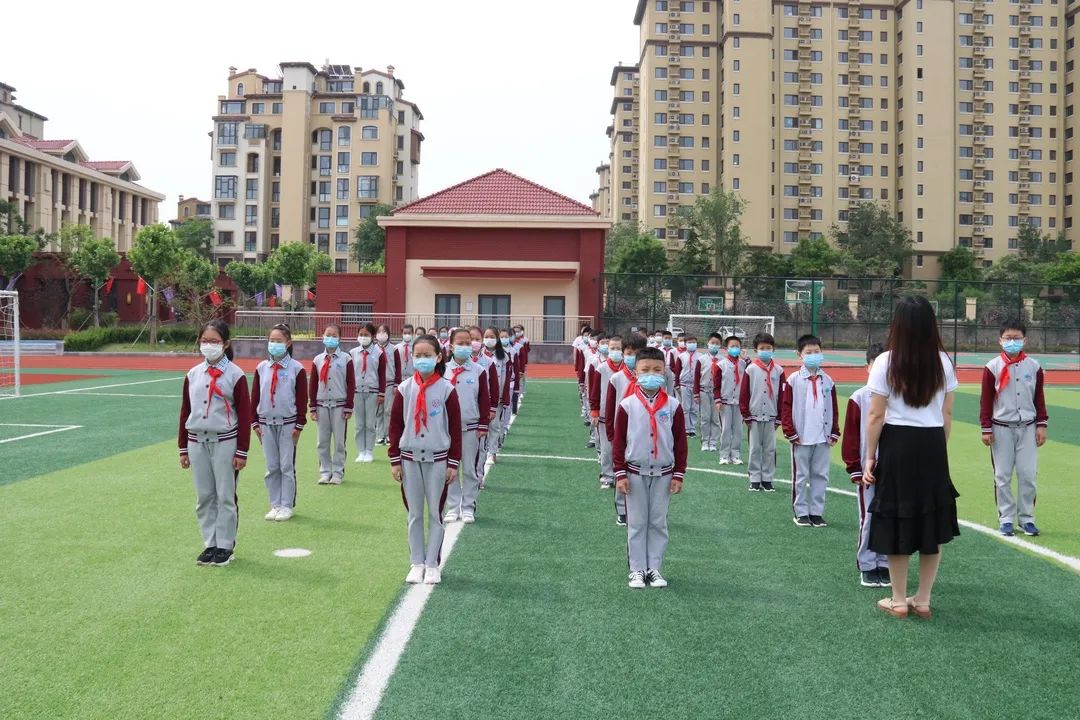 怡海小学的学生在绿茵场地上排列整齐上马中心小学复学第一天,学生