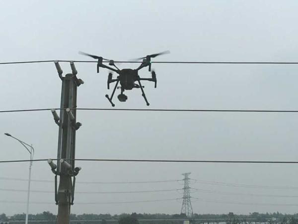 南方電網廣東廣州供電局利用5G+無人機防止外力破壞,對誤闖進電力設施保護區的施工車輛喊話喝止。(李文梓)