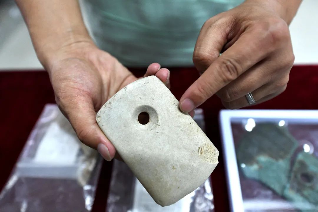 出土的石钺,中孔部位已被打磨的十分圆润.
