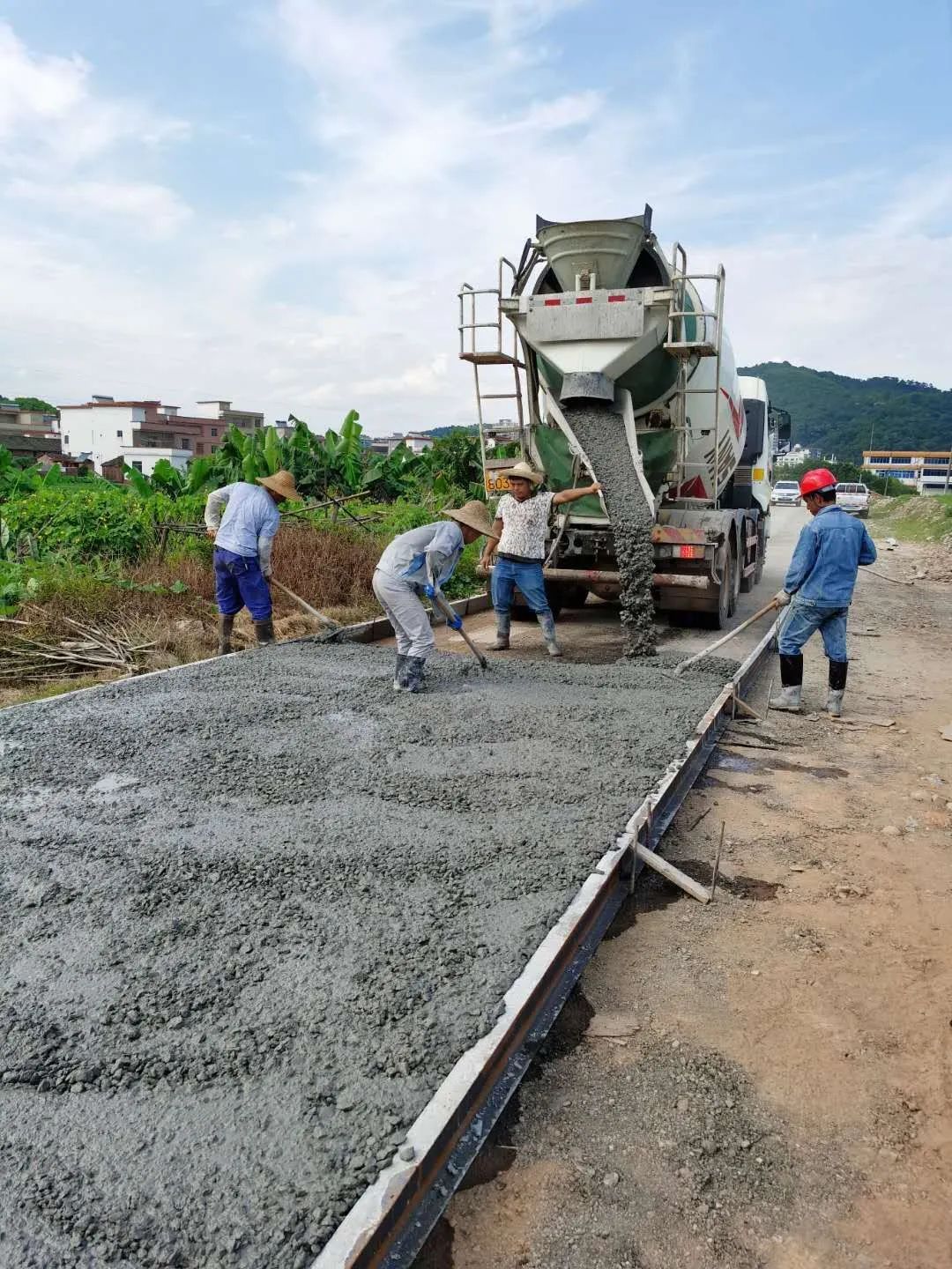 伴随着现场指挥声和机器轰鸣声,工人们熟练地操作着摊铺机,一条平整的