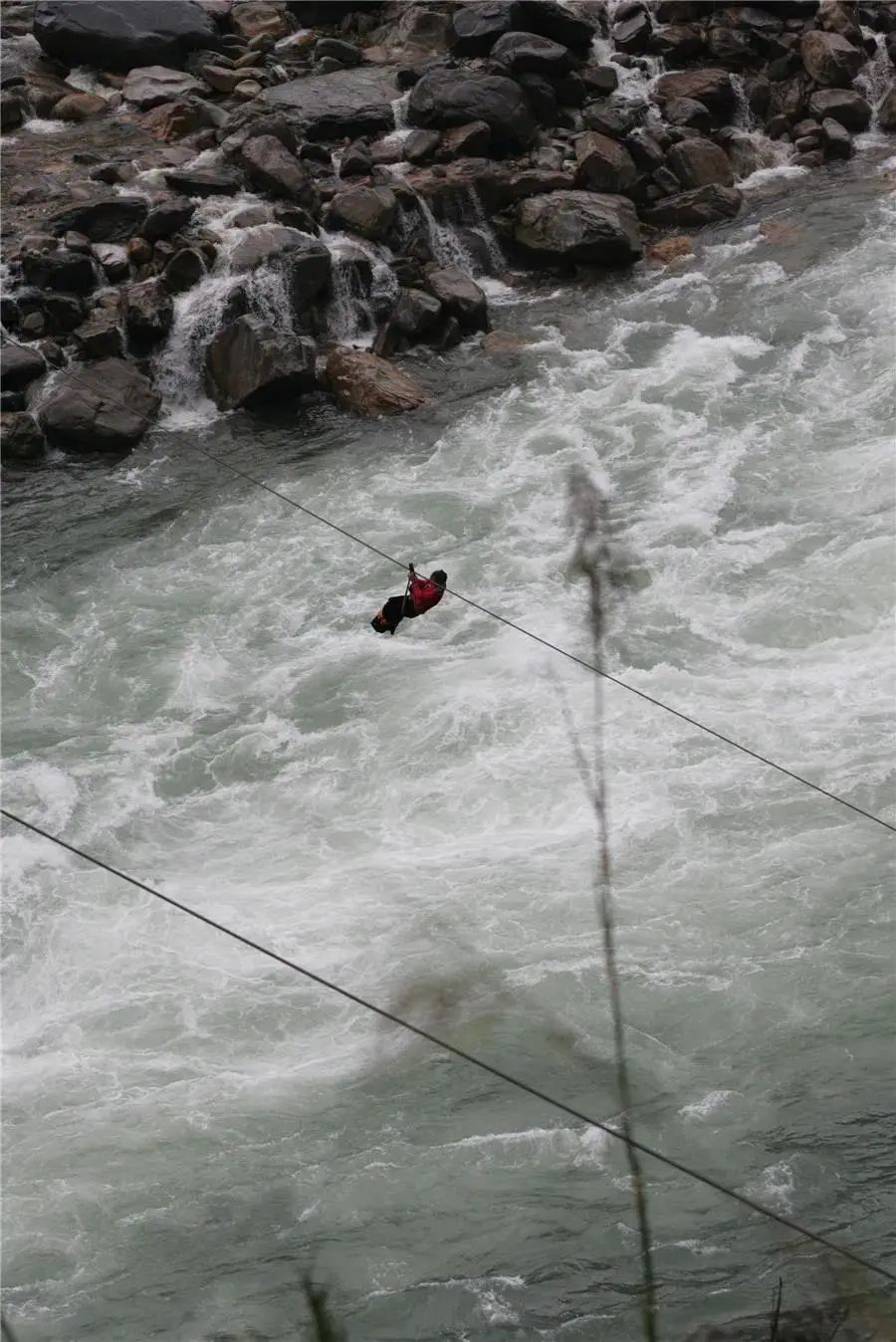 云南网回忆起孩童时代挂着溜索从浪尖上划过的艰险,37岁的傈僳族汉子