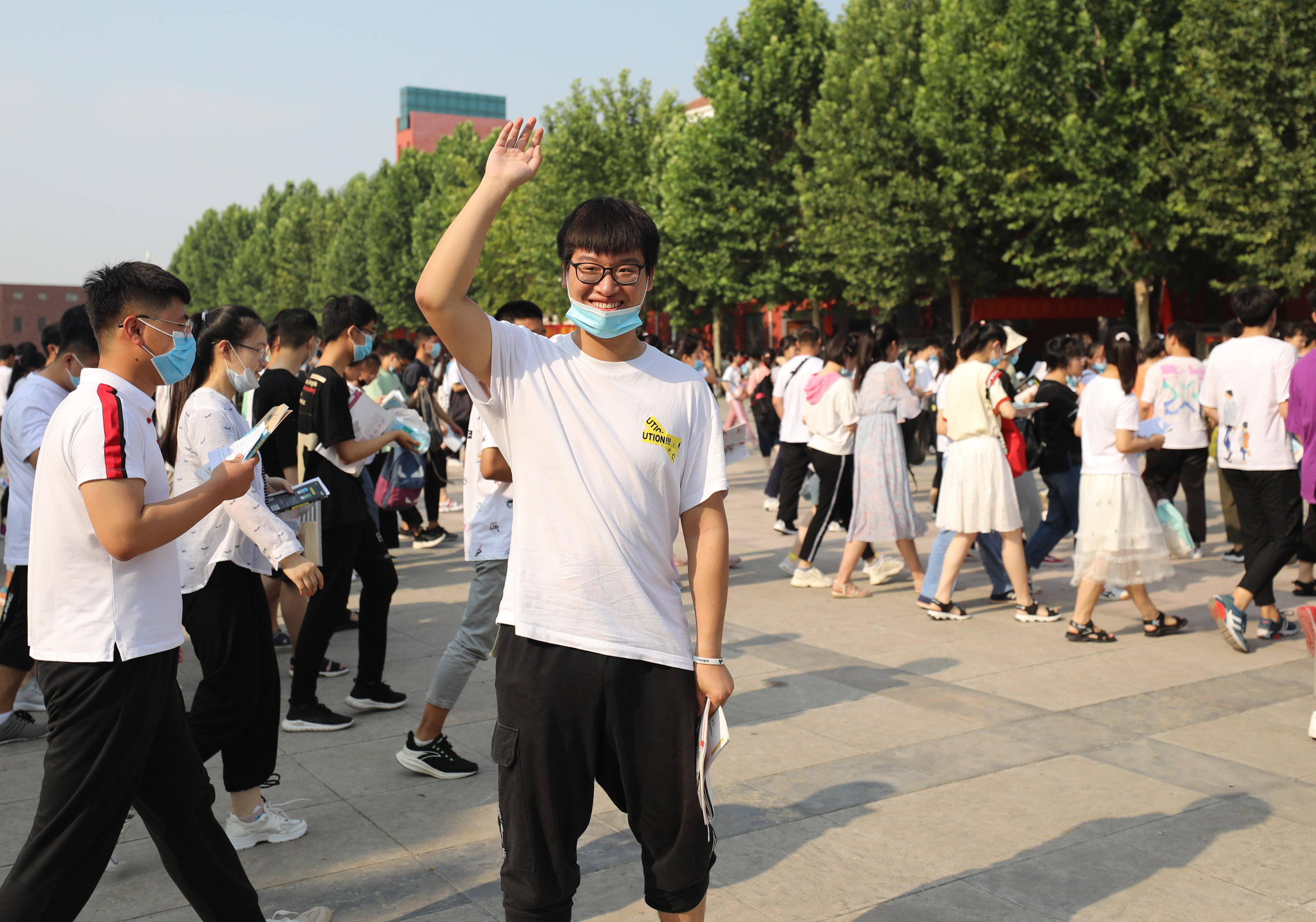 7月7日,在河南省焦作市溫縣一中考點,一名考生在進入考場前與老師揮手