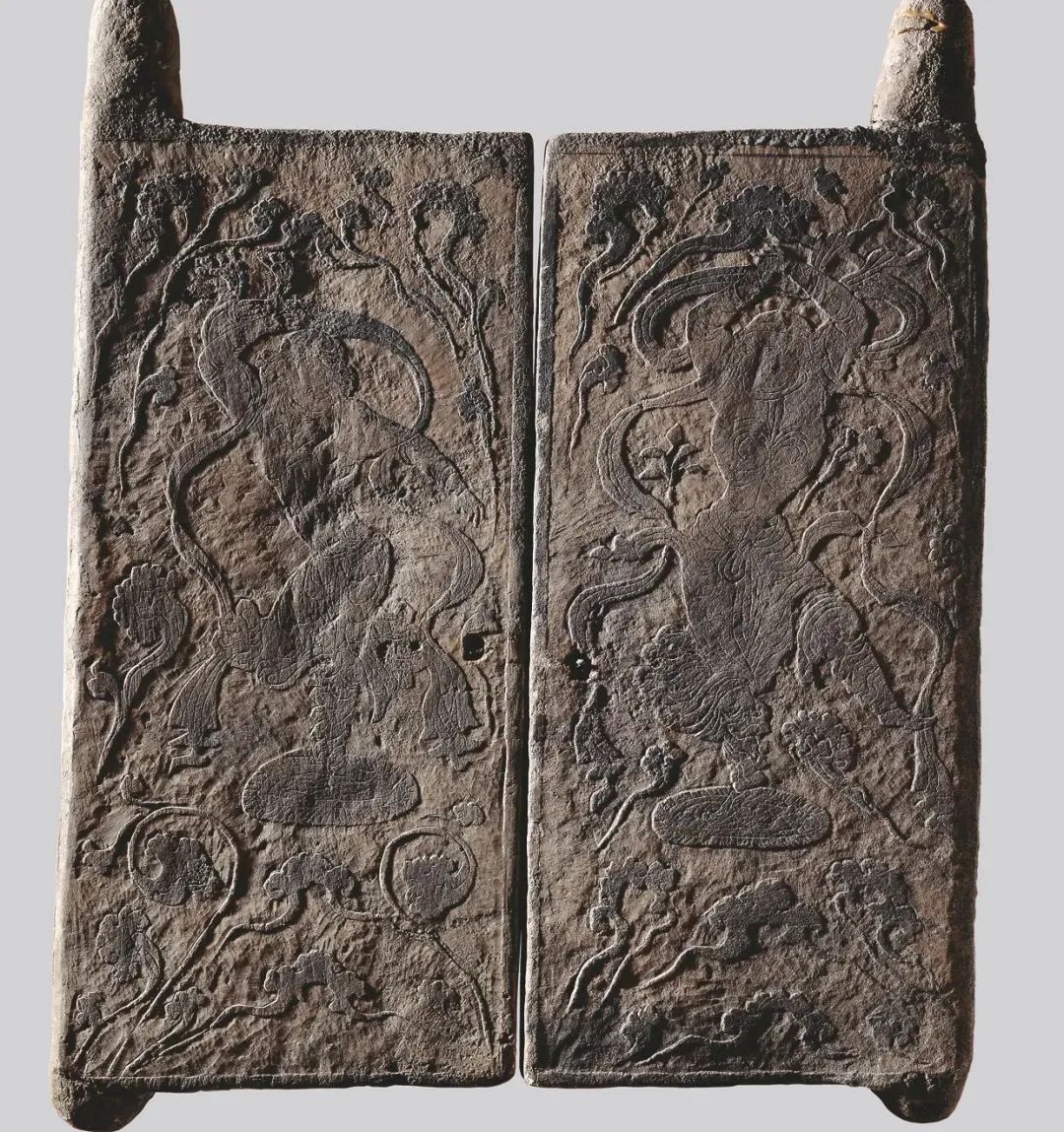 两扇石门正中各浅雕一胡人形象的男子,站在小圆毯上双人对舞,画面以