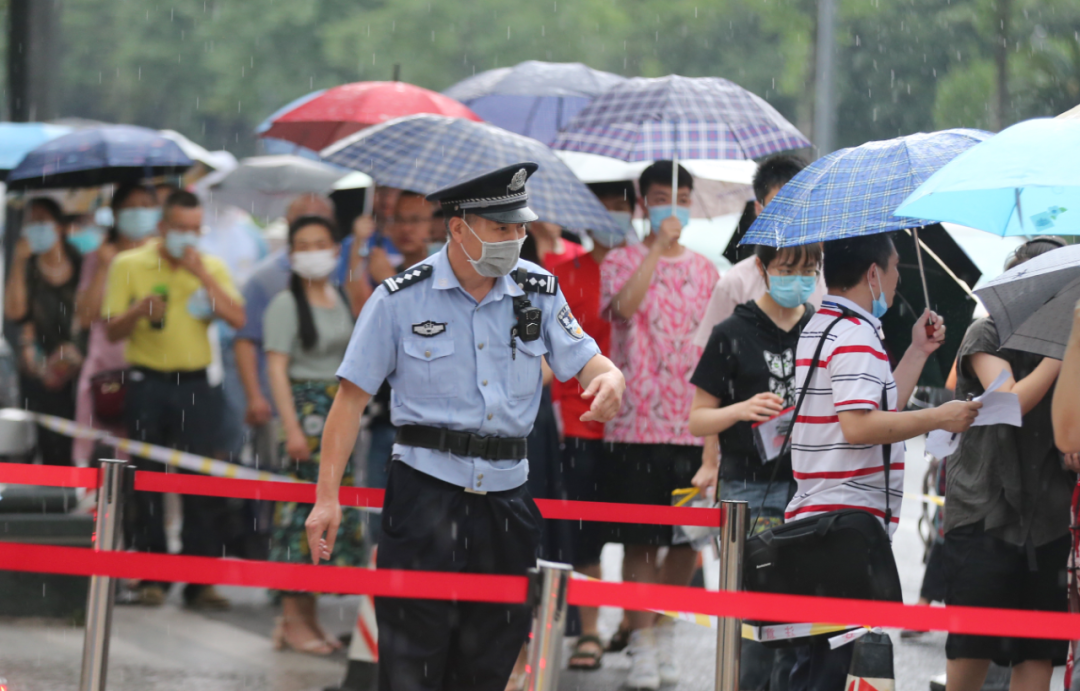 7月7日,四川省成都市公安局民警在雨中维持考点秩序.吴书满