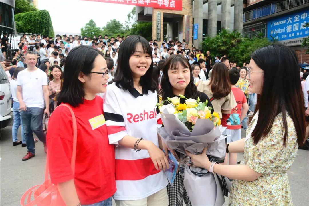 7月8日,梁平一中考点,家长和好友为考生献花.