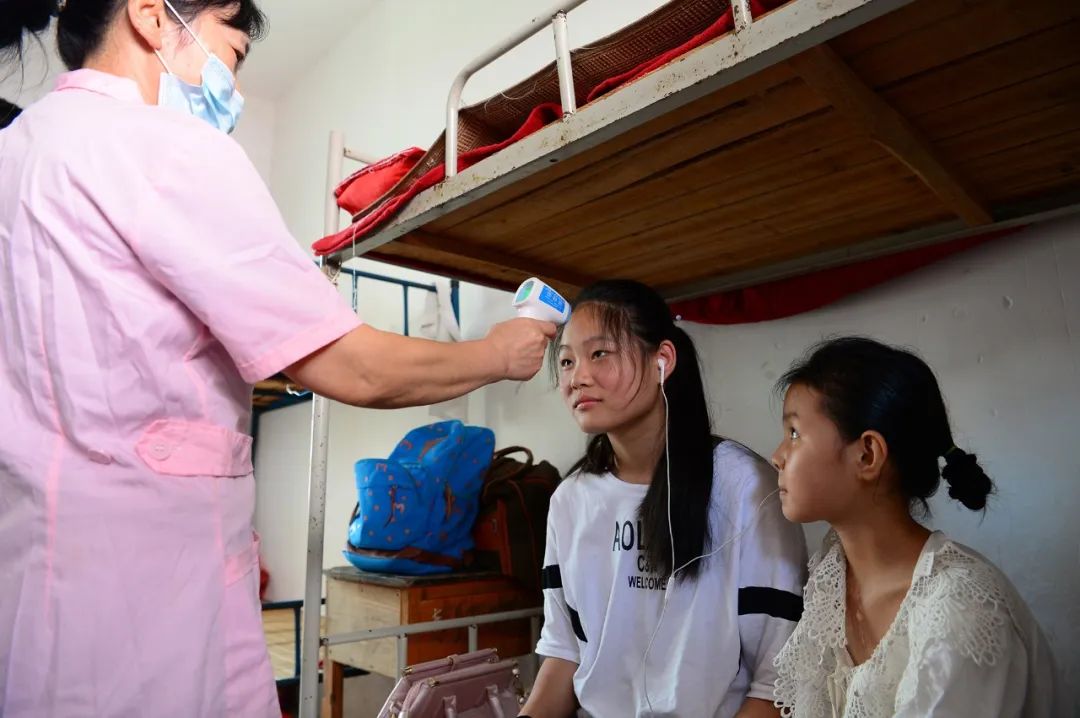 7月14日,江西省鄱陽縣油墩街中學安置點,醫護人員正對受災群眾進行