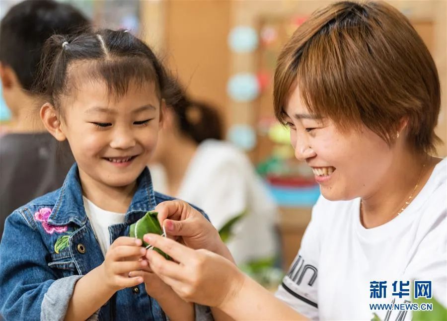 家长与孩子一起包粽子.新华社发(郑家裕 摄)