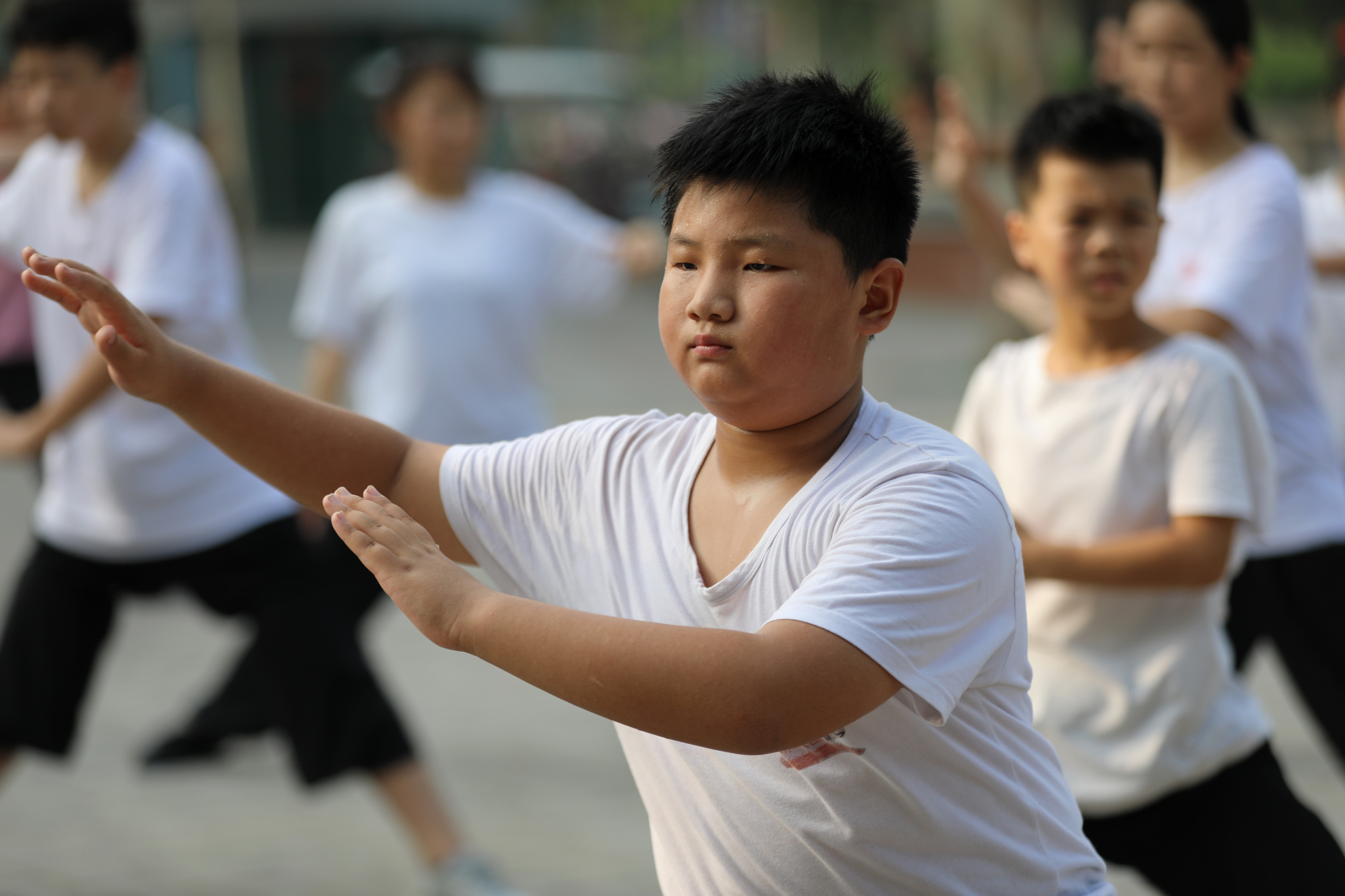 7月29日,在河南省焦作市温县太极游园,太极拳培训班的学员们在习练