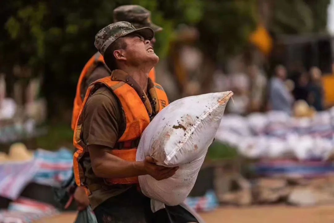排险顶着烈日扛着沙袋日夜奋战在抗洪抢险一线的解放军我看到一夜之间