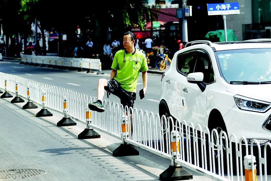 翻越栏杆过马路切勿漠视安全走捷径