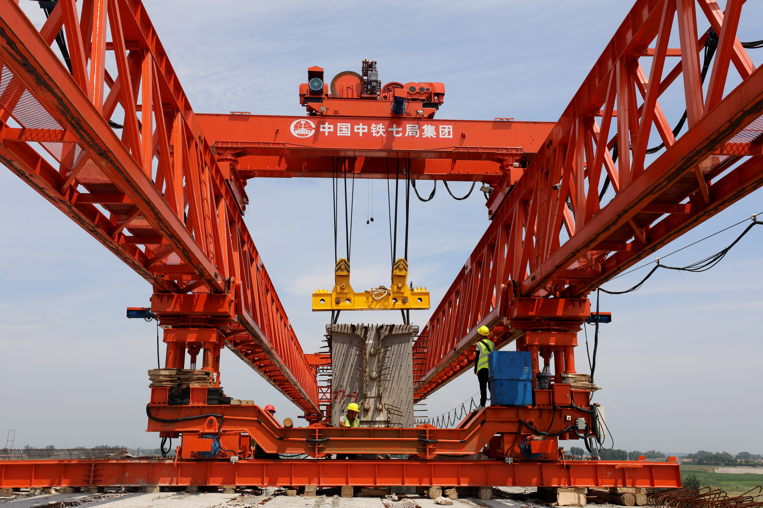 8月3日，建设者们在G207河南焦作至温县快速通道项目沁河特大桥工地架设桥梁。