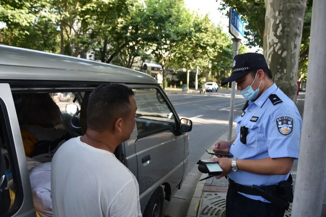 周家桥派出所民警冯翔在长宁路锦屏路路口对非机动车违法行为进行处罚