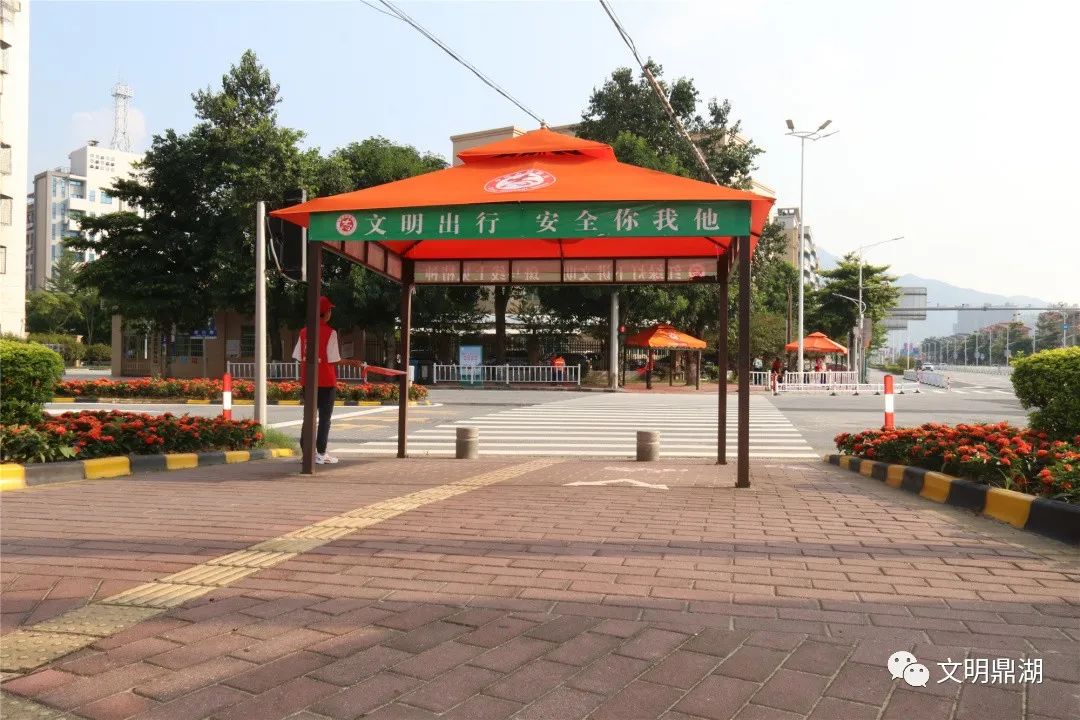 肇庆发布行人过马路. 志愿者在指挥行人按交通灯指示过马路.