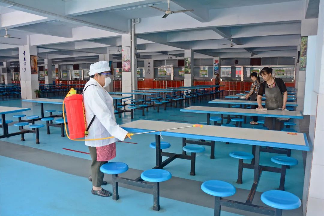 8月27日,梁平中学,后勤工作人员在学生食堂进行消毒,清洁