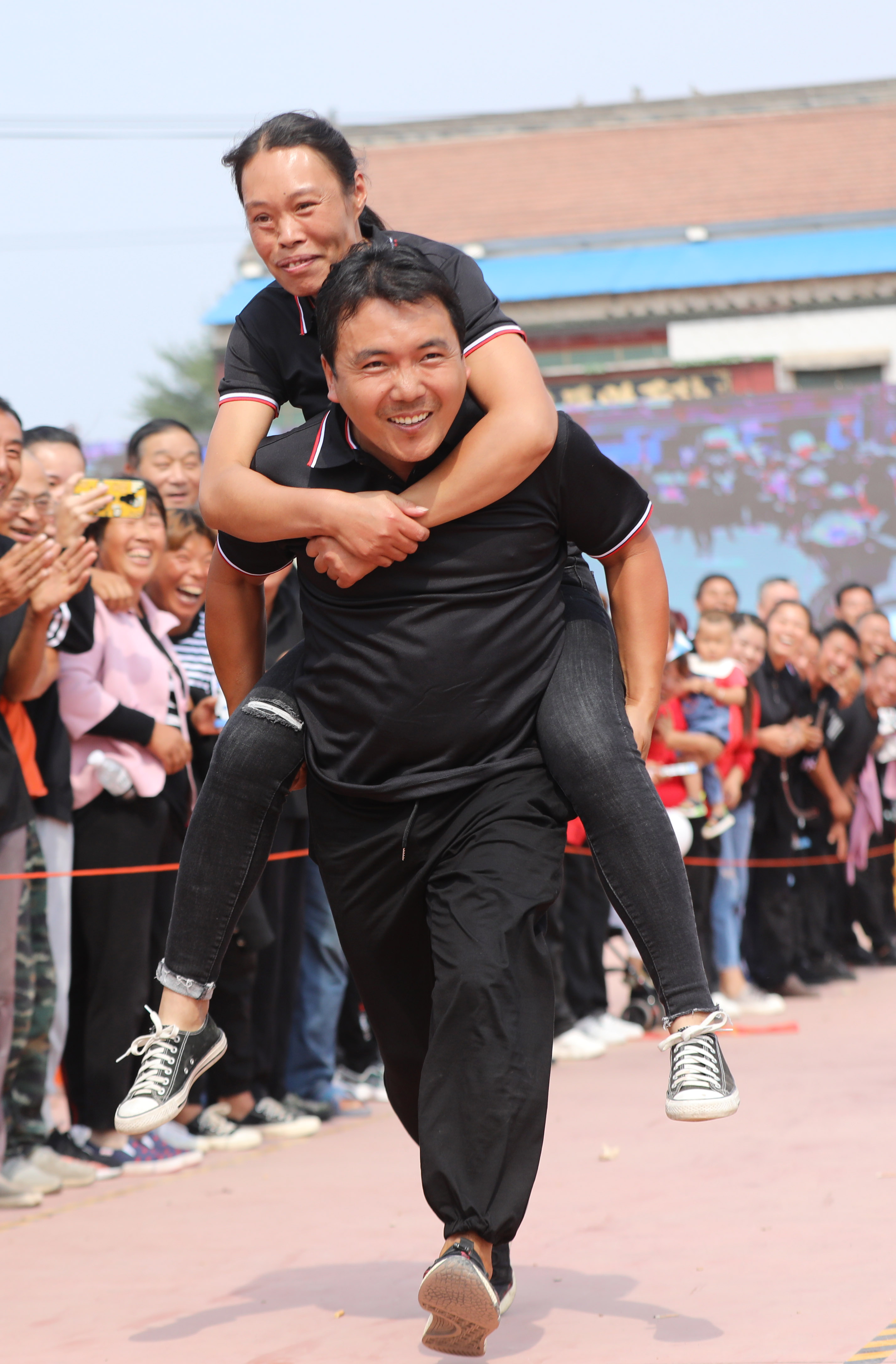 9月22日,河南省温县黄河街道办事处农民在参加夫妻互背接力跑比赛.