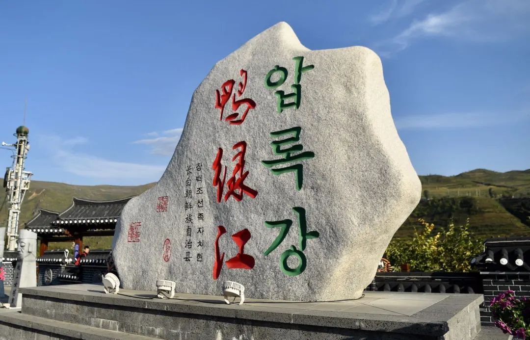 江畔,一块篆刻着"鸭绿江"三个字的石碑伫立在路边,引得游人纷纷拍照