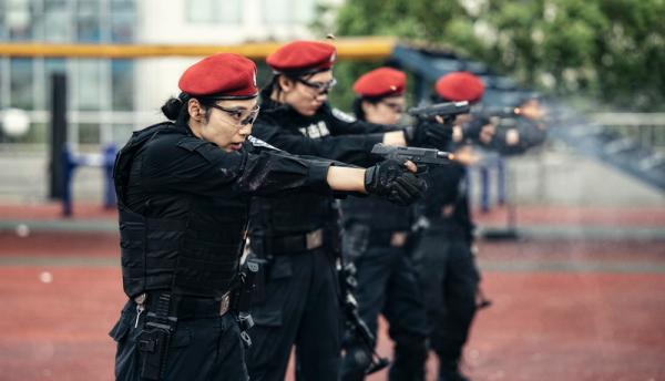 完成任务;五名女子特警队员头戴红色贝雷帽,相互掩护向前推进,随着