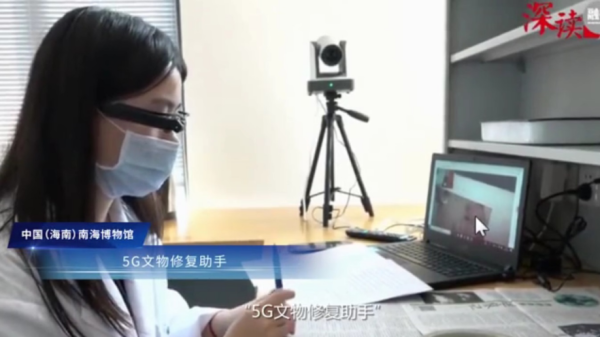 朱晓敏头戴有具备5G传输功能摄像头的“眼镜”进行文物修复操作
