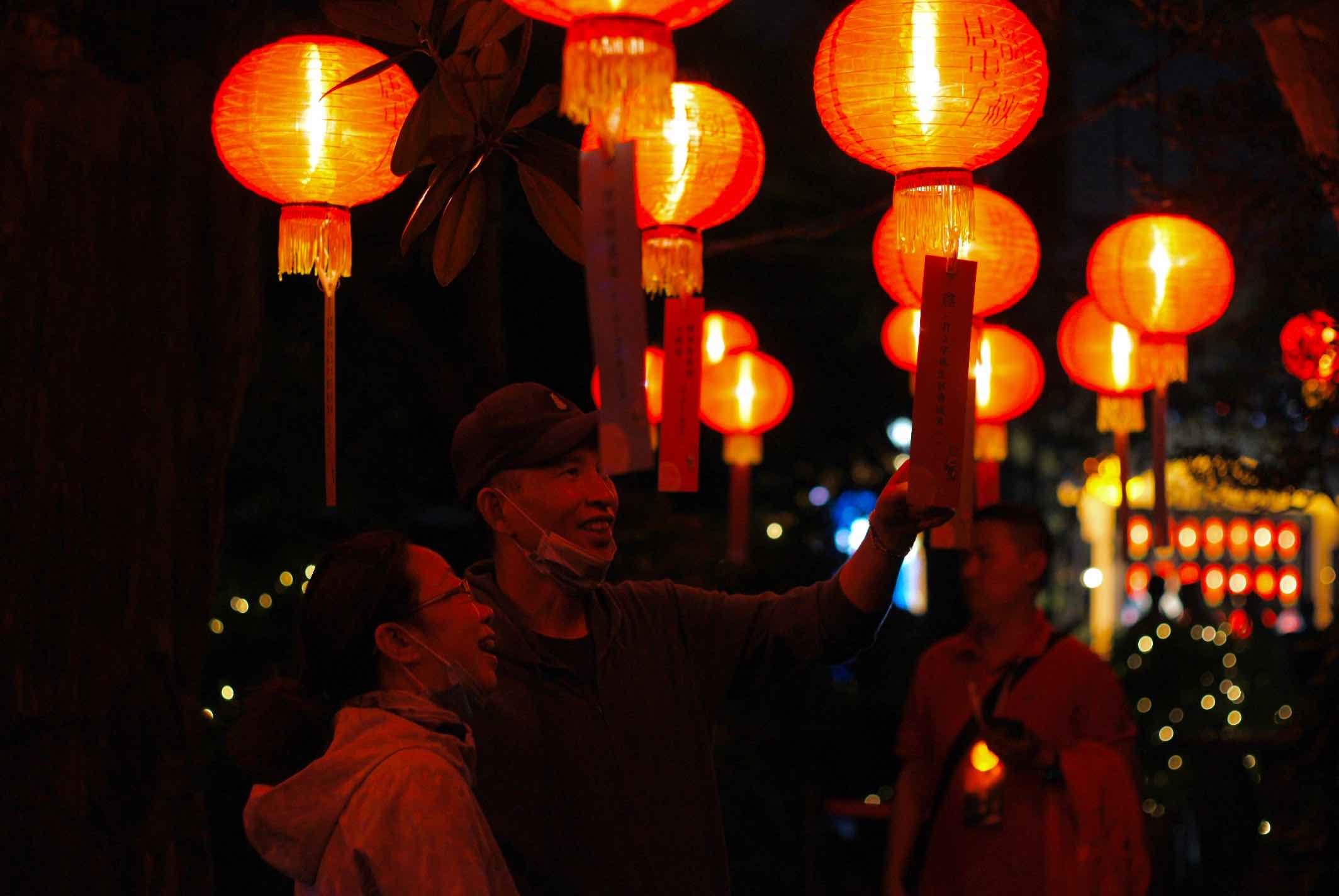 还会听到细碎的讨论声,那是对面桂花树下的游客们在猜灯谜