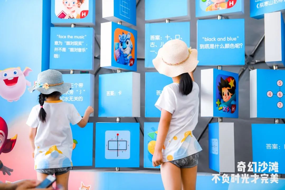 大家可以选择挑战左侧的翻转问答墙,或是旁边的电子互动区,通过智能