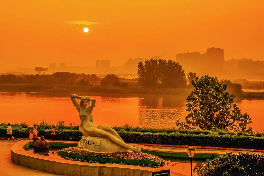 朝阳映辉 2015年7月29日,四川南充市嘉陵女神半卧嘉陵江边,在朝阳的