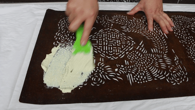 调制染浆蓝印花布是传统的镂空版白浆防染印花,用石灰,豆粉合成灰浆