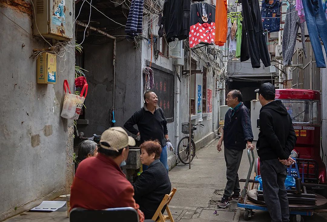 随便走进一条小弄堂,总能看见街坊邻居们或坐或站在谈笑聊天,而弄堂的
