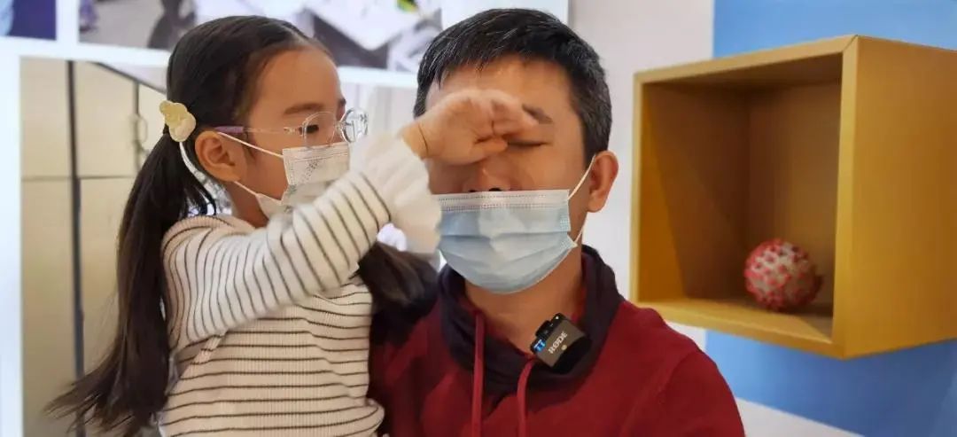 女儿用手帮爸爸擦眼泪.