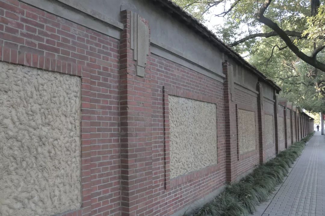 清水红砖的外墙夹饰着水泥拉毛条块,墙垛之间是数面铁窗,还有一扇不到